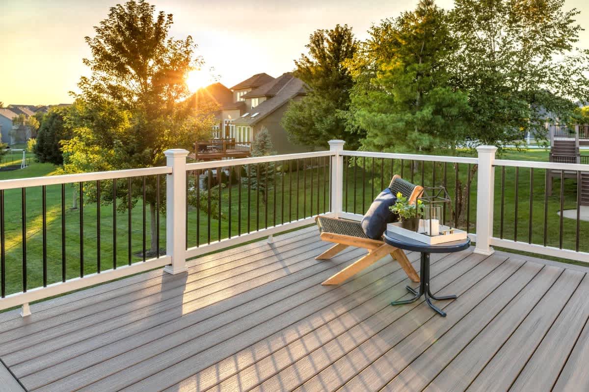 Decks — composite deck with white and black railing at sunset